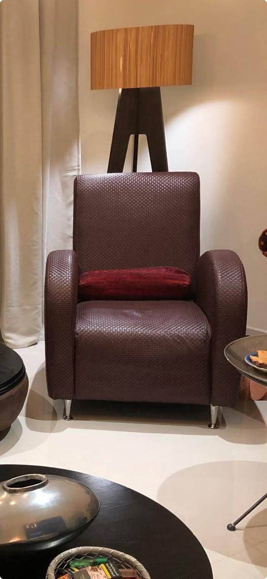 Contemporary style armchair is upholstered in dark brown